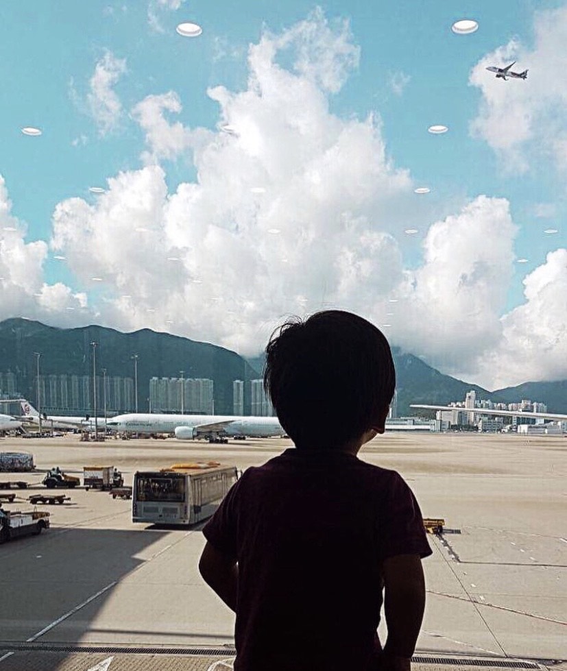 Photo of a toddler at an airport looking out the window at airplanes. This is his first move and first goodbye.